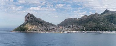 Atlantik Okyanusu 'ndaki Hout Bay Koyu' ndaki Hout Bay köyünün manzarası Chapman 'daki Doğu Kalesi' nden çekilen Cape Town, Batı Cape, Güney Afrika 'da yaz güneşinde sürülüyor.