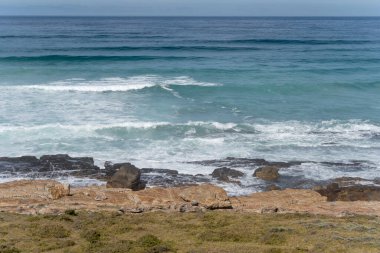 Misty Cliffs 'de kayalık kıyılarda Atlantik Okyanusu dalgaları olan manzara, parlak yaz ışığında, Cape Town, Batı Burnu, Güney Afrika