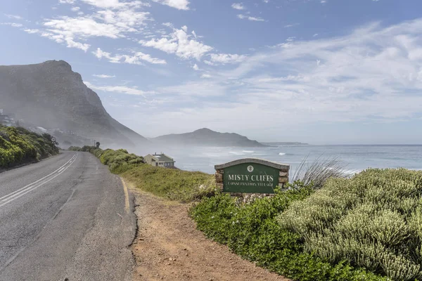 霧の崖で大西洋の緑の海岸沿いの風光明媚な海岸沿いの道路と風景 海霧と明るい夏の光の中で撮影 ケープタウン 西ケープ 南アフリカ — ストック写真