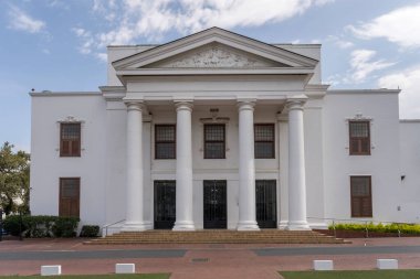 Parlak bulutlu yaz ışığında çekilen Neoklasik Belediye Binası cepheli şehir manzarası Stellenbosch, Batı Burnu, Güney Afrika