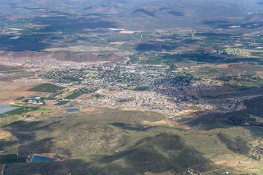 Robertson 'ın küçük kasabası ve çevresindeki yeşil tepe ile planörlü hava manzarası, kuzeyden parlak bulutlu yaz ışığında çekiliyor, Batı Burnu, Güney Afrika