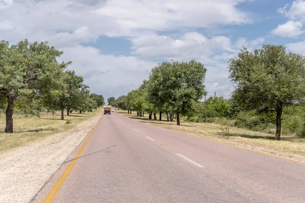 stock image landscape with little traffic on R40 tree-lined road in countryside near Timbavati, shot in bright summer light , Mpumalanga, South Africa