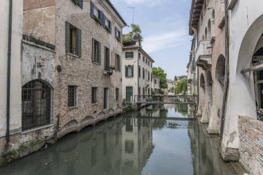 Treviso, Veneto, İtalya 'da çekilen evler arasında Buranelli Kanalı üzerinde demir köprülü şehir manzarası