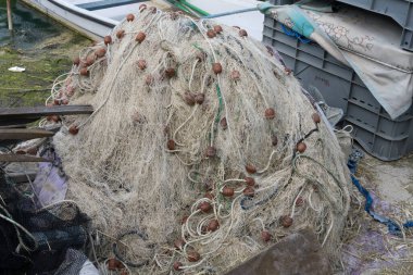 Caneo 'nun doğal alanı Grado, Gorizia, Friuli, İtalya' daki Punta Sdobba köyünde parlak ışıkta çekilen küçük liman setine balık ağı yığıldı.