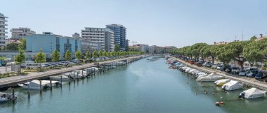 GRADO, ITALY - Haziran 01 2023: Schiusa Kanalı 'nın kıyısında demirlemiş tekneleri olan şehir tarihi kenti, Haziran 01' de parlak bir ışık altında çekilen ve Bullesi Köprüsü 'nün batısına bakan, 2023 Grado, Gorizia, Friuli, İtalya
