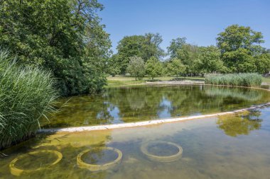 Cityscape with shallow waters of lake at public park. Shot in bright summer  light  at Stuttgart, Baden Wuttenberg, Germany