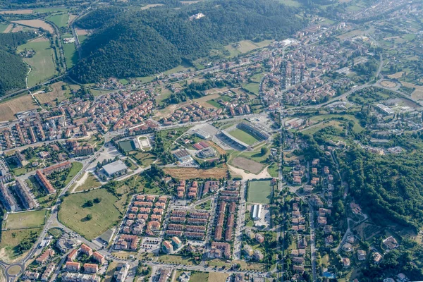 Rieti 'nin doğu semtlerindeki stadyumlu planörlü bir uçaktan havadan çekilen şehir manzarası. Kuzeydoğudan çekilen parlak yaz ışığı Apennines, Lazio, İtalya