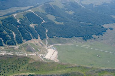 Bir planör uçağından, dağlık bir tepede, güneydoğudan Campo Felice, Apennines, L 'Aquila, Abruzzo, İtalya' da parlak yaz ışığında çekilen hava manzarası.