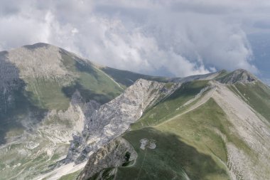 Kuzeyden Norcia, Apennines, Perugia, Umbria, İtalya yakınlarındaki parlak yaz ışığında kayan Vettore peal zirvesi ve deniz meltemi bulutlarından oluşan bir planör uçağının havası.