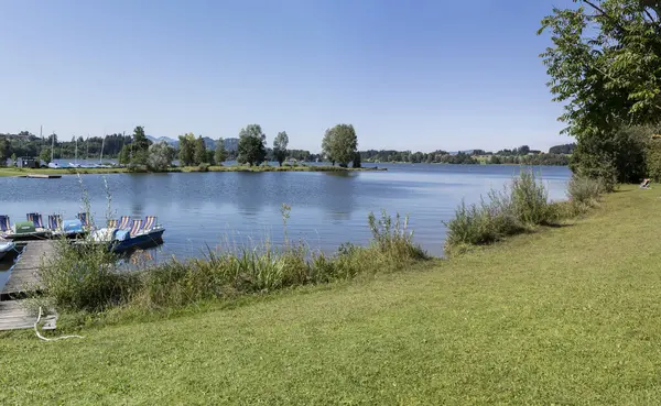 Petersthal, Allgaeu, Bavyera, Almanya yakınlarındaki Rottachsee Alp Gölü 'ndeki küçük körfezde çekilen tekne ve demirli manzara.