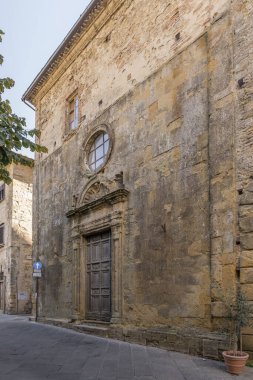 San Dalmazio kilise cephesi ve Rönesans portallı şehir manzarası, Volterra, Toskana, İtalya 'da parlak bir sonbahar ışığı altında çekildi.