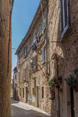 Tarih kasabasında dar sokaktaki eski taş evlerle dolu bir şehir. Volterra, Toskana, İtalya 'da parlak bir sonbahar ışığı altında çekilmiş.