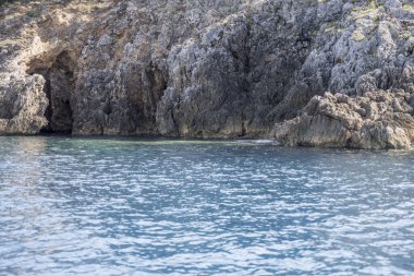 Turco Grotto ile Akdeniz kıyısındaki promontory 'de manzara, Arjantario, Tuscany, İtalya' daki parlak sonbahar güneşinde bir tekneden çekildi.