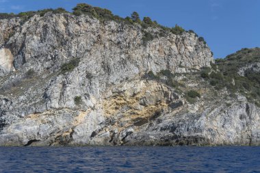 Cala Grande Burnu 'nun batısındaki sarp kayalıkların bulunduğu manzara Akdeniz kıyısında, parlak bir sonbahar sabahında Argentario, Tuscany, İtalya' da çekilmiş.