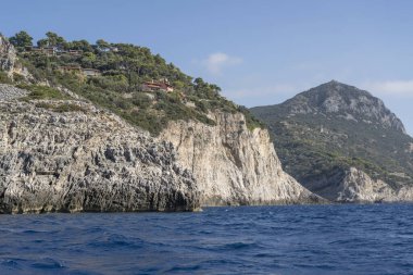 Bove Burnu 'nun dik kayalıklarıyla Akdeniz kıyısında, Arjantario, Tuscany, İtalya' da parlak sonbahar ışığı altında bir tekneden çekilen manzara