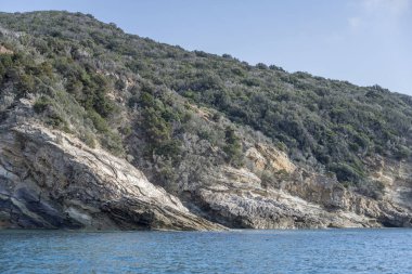 Akdeniz kıyısındaki Promontory 'de Purgatorio Koyu yakınlarındaki kayalık kayalık kayalıklar Arjantario, Tuscany, İtalya' daki parlak sonbahar ışığı altında bir tekneden çekildi.