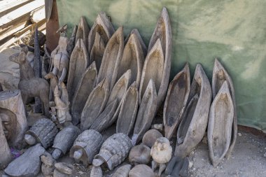 Okahandja, Namibya, Afrika 'da parlak bahar ışığı altında çekilen el sanatları pazarında küçük ahşap borular ve çeşitli eşyalar satılıyor.