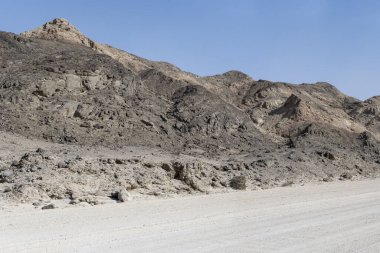 Ay manzarası çölündeki kayalık tepelerin çorak yamaçlarında, Swakopmund, Namibya, Afrika yakınlarındaki parlak bahar ışığı altında çekilen manzara.