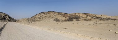Ay manzarası çölündeki kayalık tepelerin çorak yamaçlarında bazalt taşları olan manzara Swakopmund, Namibya, Afrika yakınlarındaki parlak bahar ışığı altında çekilmiştir.