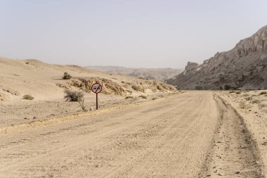 Ay manzarası çölünde çakılsız yol tabelasının olduğu manzara, Swakopmund, Namibya, Afrika yakınlarındaki parlak bahar ışığı altında çekildi.