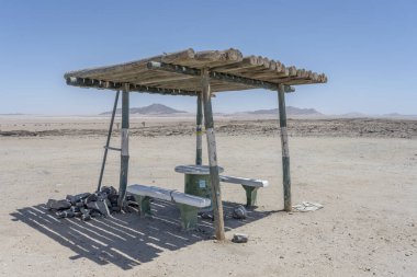 Kriess se rus, Namibya, Afrika yakınlarındaki Naukluft Çölü 'nün yol kenarındaki gölgelerde banklar.