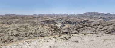 Naukluft çölünün yamaçlarındaki bazalt kaya katmanlı hava manzarası, Kuiseb 'den geçen parlak bahar ışığı ile çekildi, Namibya, Afrika