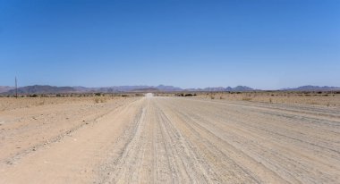 Naukluft Çölü 'nde C19 çakıl yolu olan manzara, Susriem, Namibya, Afrika yakınlarındaki parlak bahar ışığı altında çekildi.