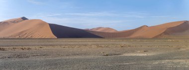 Naukluft Çölü 'nde Sossusvlei, Namibya, Afrika yakınlarındaki parlak bahar ışığı altında çekilen büyük kırmızı kumullar üzerinde ışık ve gölgeli manzara.