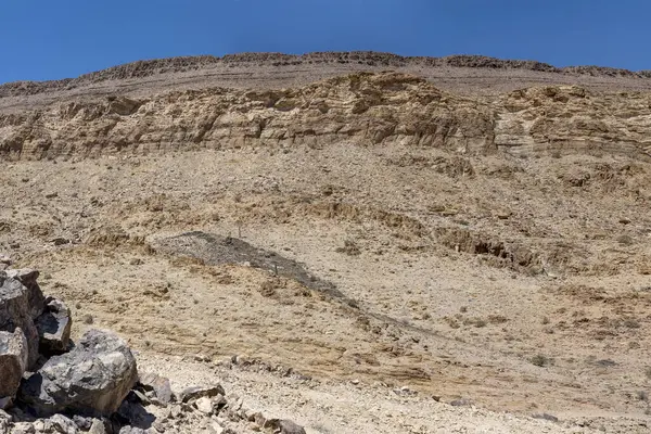 Hobas, Namibya, Afrika yakınlarındaki parlak bahar ışığı altında çöldeki dik tepe yamaçlarındaki holdingin katmanlarıyla çekilen manzara.