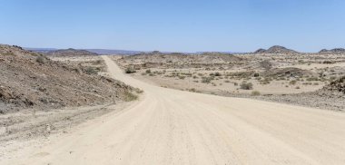 Çölde C37 çakıl yolu olan manzara, Ais, Namibya, Afrika 'nın kuzeyindeki parlak bahar ışığı altında çekildi.