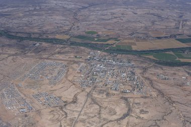 Çölde nehir kenarındaki şehir havası, doğudan Mariental, Namibya, Afrika 'da parlak bir bahar ışığı altında planörlü uçaktan çekiliyor.