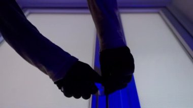 Saldırgan polis takibinden saklanıyor. Eldivenli eller plastik kapıları ve opak pencereleri açar ve bir insan dışarı çıkar. Yüksek kalite 4k görüntü