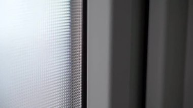 Karanlıkta plastik kapılı, opak camlı, çift camlı bir pencere. Plastik bir kutunun desenli penceresi. Pürüzsüz kamera hareketi. Beyaz ön kapılar. Yüksek kaliteli FullHD görüntüler