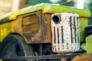 Bir traktörün egzoz borusunun egzozu küçük bir dizel motorun arka planına karşı.