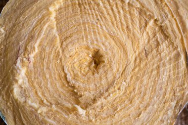 Cam yün rulo yakın çekim kesim. Ses ve ısı yalıtımı için inşaat malzemelerinin arka planı. Yuvarlak sarı cam yün.