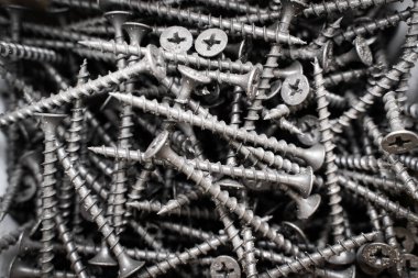 Siyah, uzun, kendi kendine dokunan vidalar bir kutuya yakın çekim yapar. Tahta vidalar