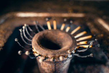 Yakından çekilen bir gaz sobasının ocağında yanan kibrit yerine, yanmış ahşap kibrit. Düşük yaşam standardı, kötü koşullarda hayatta kalma. Doğal gaz tasarrufu. Gecekondu mahallelerine giden mavi yakıtı kesiyorum.