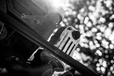 Bir traktörün dizel motoru ve yakın çekiş kayışı. Güneşin siyah ve beyaz parlaklığıyla öngörülmüş alt görünüm