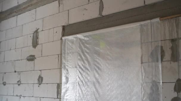 门是用蒸汽屏障封住的 用白色的充气混凝土砖制成的未完工房屋的光秃秃的墙壁 镜头动作平稳 优质Fullhd影片 — 图库视频影像