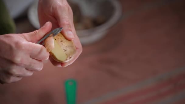 在模糊的背景下 用手用特殊的小刀削土豆 高质量的4K镜头 — 图库视频影像