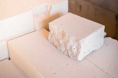 Spalling 'in olduğu yerde düşük kalite kırılgan havalandırmalı beton kaplama. Bozuk beyaz havalandırmalı beton tuğla. İnşaat alanında kötü inşaat malzemeleri var.