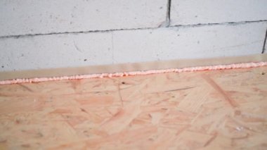 OSB alt katı ile havalandırılmış beton duvar arasındaki boşluk inşaat köpüğüyle dolu. Pembe bina köpüğüyle açılan kapakların termal yalıtımı, pürüzsüz kamera hareketi. Yüksek kalite FullHD