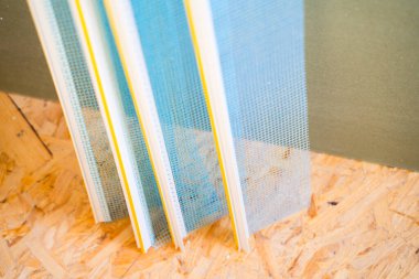 Pencere kenarındaki PVC profili bir manşet ve devekuşu plakasına yakın mavi bir ağ ile.