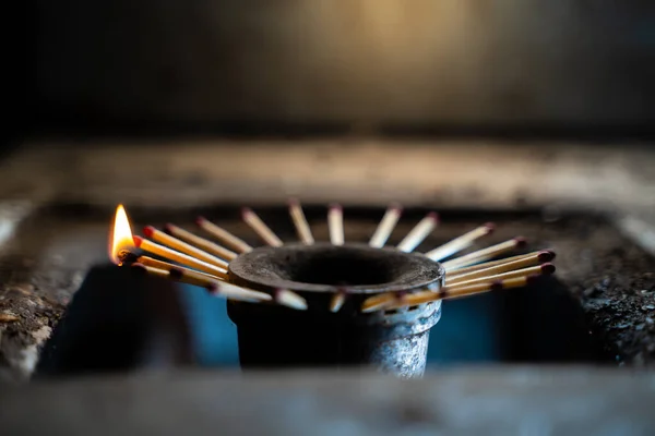 A certain number of household wooden matches sticking out of a gas stove burner. The absence of blue fuel in the kitchen gas stove. Search for alternative fuel for heating. Bad living conditions
