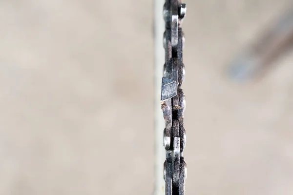 Chainsaw chain close-up on a blurred background, top view. Tool maintenance, copyspace
