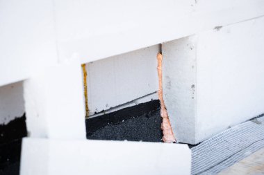 Bir evi polistiren köpük izolasyonuyla izole etme süreci. İnşaat köpüğü ile duvara kalın bir köpük tabakası yapıştırılır.