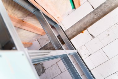 Metal bir profilin iç bölümünün altında inşa edilmiş. Tamiri olmayan özel bir evin duvarını çerçevele. Bölme duvarını havalandırılmış beton tuğlalara bağlıyorum. Güçlendirilmiş hafif yapı