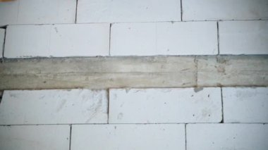 Wall of aerated concrete bricks with a concrete reinforced belt close-up. Smooth camera movement at a construction site. High quality FullHD footage