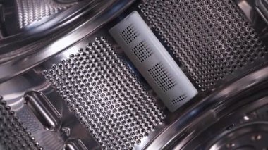 Smooth movement of the chamber from inside the drum of a top-loading washing machine. Shiny surface of perforated stainless steel in household appliances. High quality FullHD footage