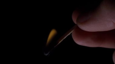 An ordinary wooden match lights up in the hand in the dark close-up. Lighting and extraction of heat with a match in a bunker or basement. High quality 4k footage